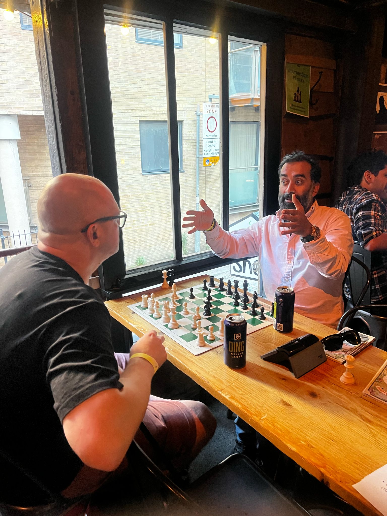 Two players in animated conversation over a chess board